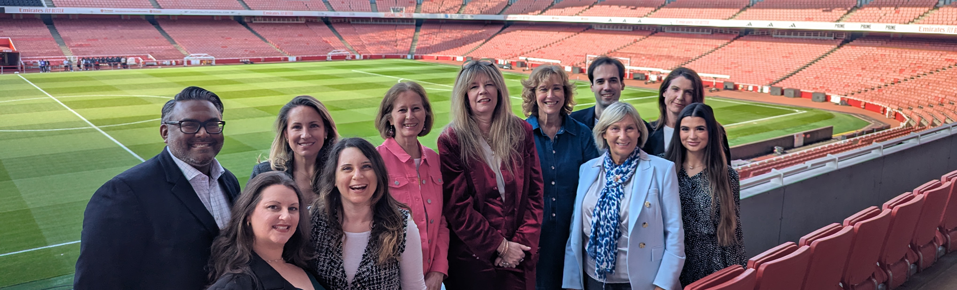 The London Convention Bureau team standing in front of the Emirates Stadium pitch