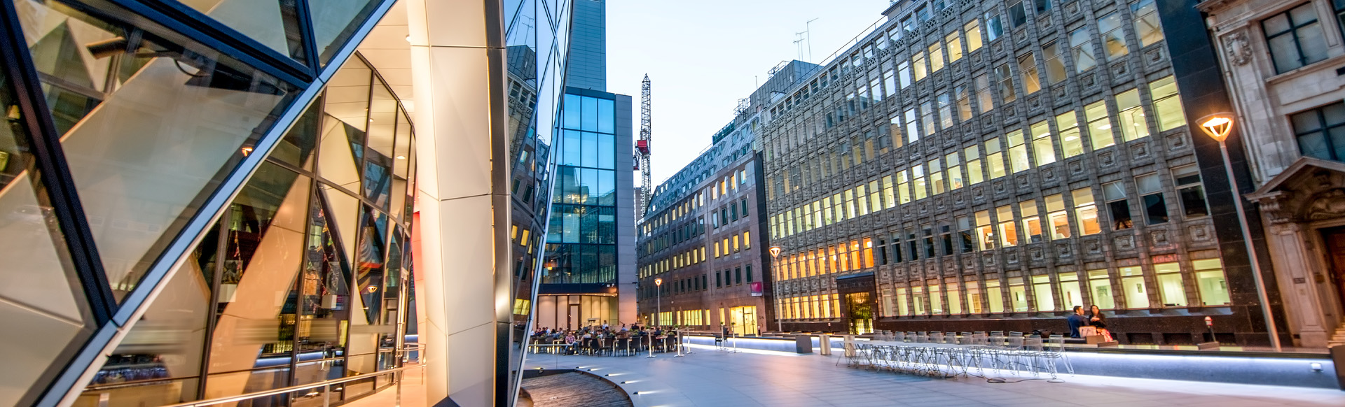 A clean, financial district street with modern and historic buildings on both sides.