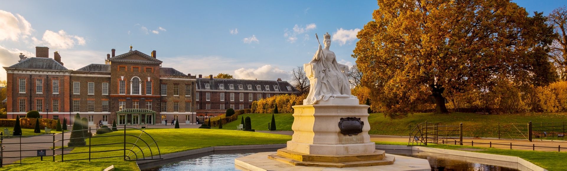 White fountain sculpture in Kensington Gardens on an autumn day.