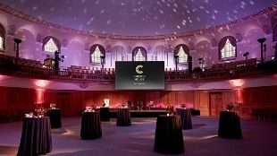 Event space at Church House Westminster in London lit up in purple-orange light.