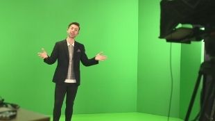A man stands in front of a green screen at the Kimpton Fitzroy London studio.