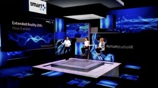 The Royal Lancaster Hotel virtual reality studio in London, with three people sitting on stage.