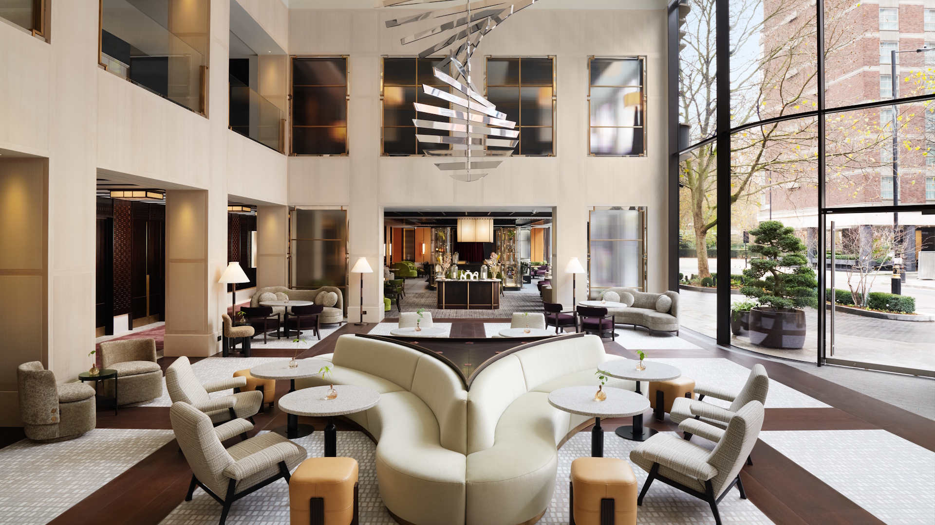 Elegant hotel lobby with beige sofas and chairs and natural light.