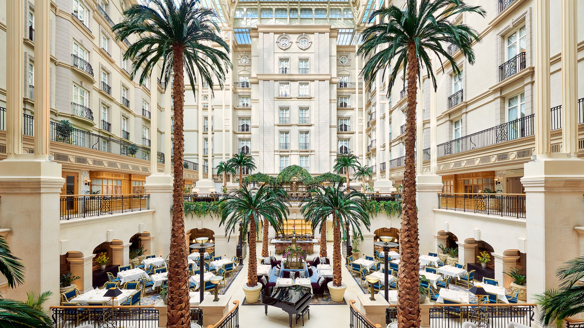 The Landmark London's courtyard with palm trees and natural lighting.