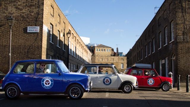 A blue mini car, a white mini car and a red mini car, parked in a row.