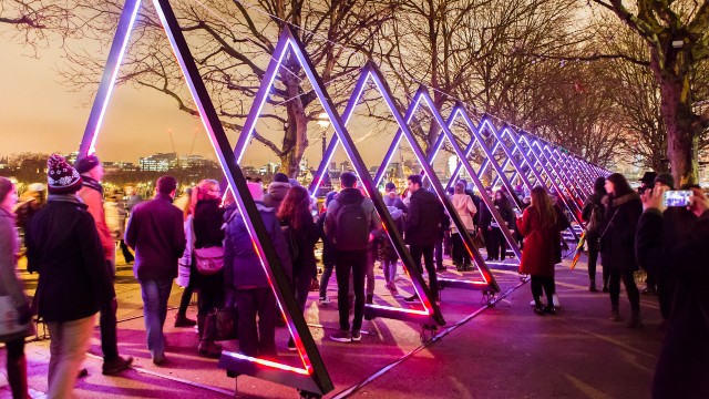 Lumiere London light festival featuring colourful triangles at night with crowds attending.