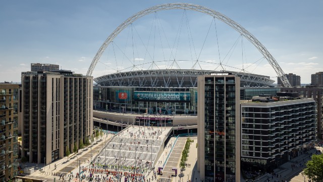 Exterior view of Wembley Stadium in London. Crowds arrive to watch a UEFA EURO 2020 match.