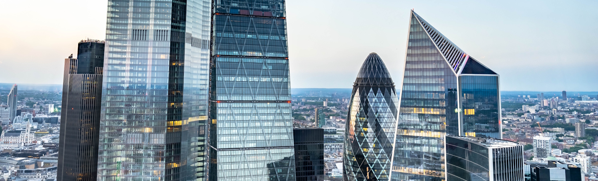 Skyscrapers in the City of London including The Gherkin on a clear day with the city in the background.