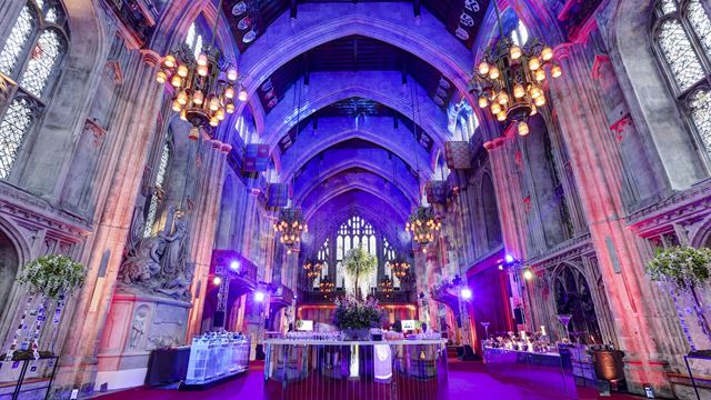 Guildhall's magnificent interior. Credit: Matt Chung Photo. Image courtesy of Guildhall. Guildhall's magnificent interior with grand columns, stained glass windows and arches on the ceiling, lit up in pink, yellow and blue lights.