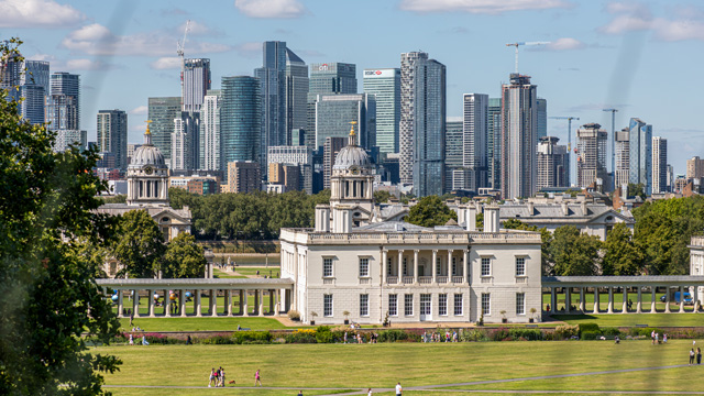 A view of the historic Queen's House in Greenwich with Canary Wharf skyscrapers in the background.