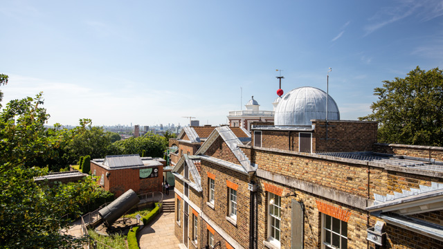 A view of the historic Royal Observatory building with views of the city in the background.