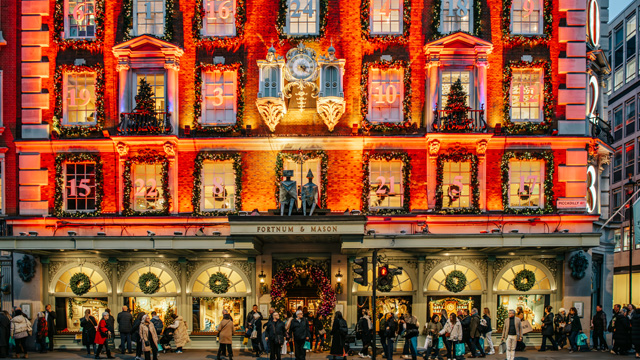 The main facade of an elegant department store decorated with lights for Christmas.
