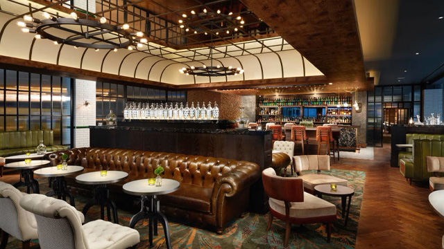 Interior of an elegant bar with leather seating and wooden panelling.