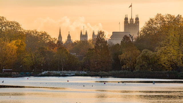 An view of the lake in St James' Park during a sunset looking towards the Palace of Westminster.