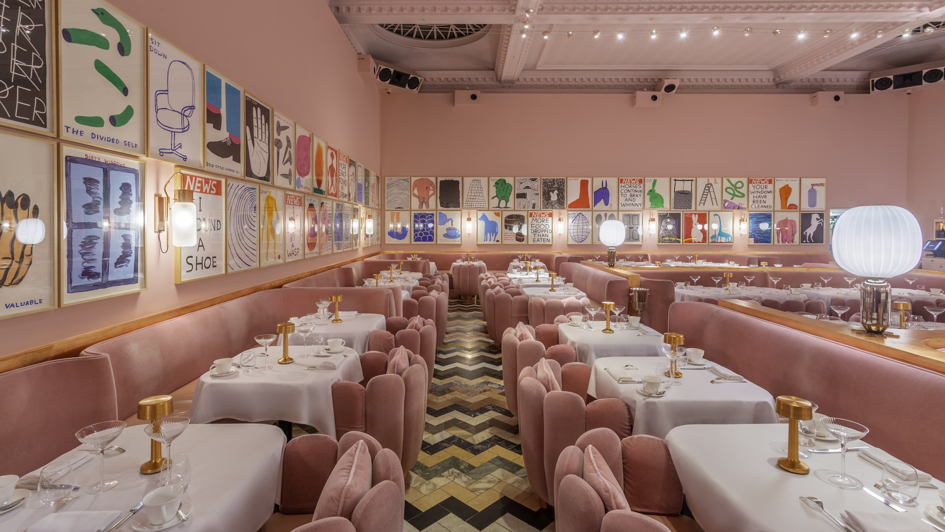 The pink room with velvet pink seats at Sketch, tables with white tablecloth and artwork adorning the walls. 