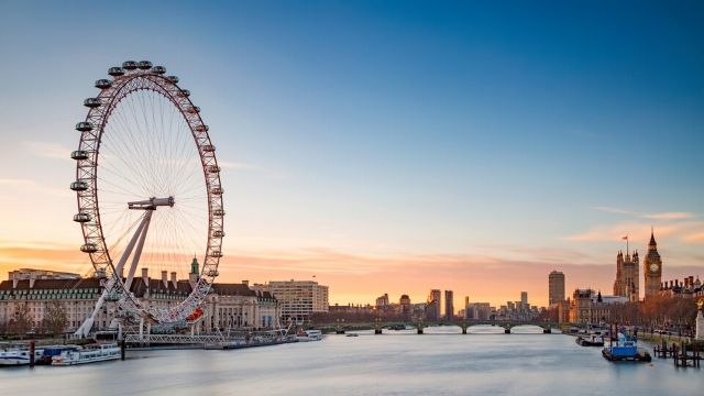 View from the river of the London Eye and Westminster, with the Big Ben during sunset.