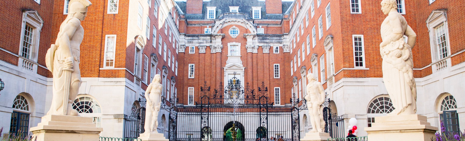 An exterior view of BMA House on a sunny day with flowers in the foreground