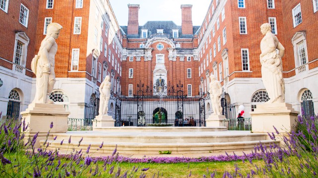 An exterior view of BMA House on a sunny day with flowers in the foreground
