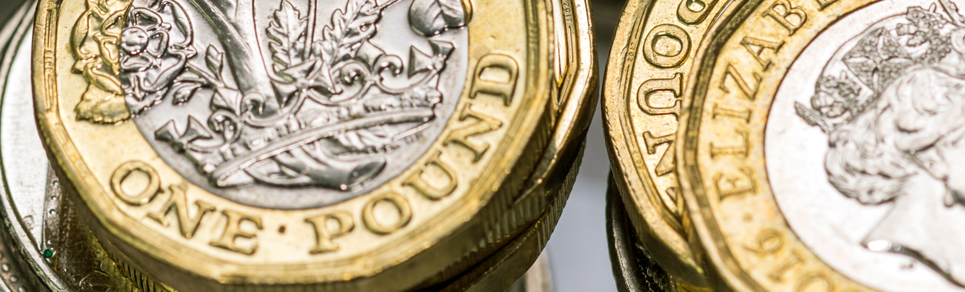 One pound coins stacked on each other.