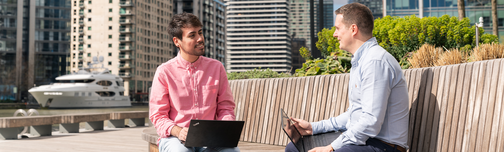 Two men with laptops having a meeting in Canary Wharf
