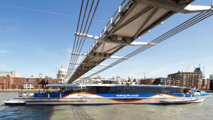 Millenium Bridge in London with a boat on the river